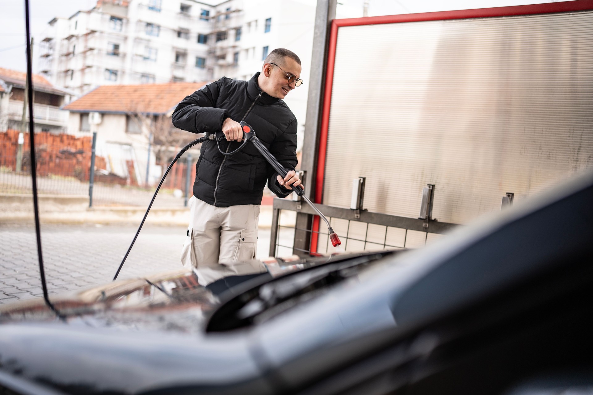 Man Washing a Car at an Outdoor Self-Service Cleaning Station